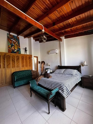 A bedroom with a bed, a bench, a wardrobe, and a ceiling fan. - La Casa del Banquete (San Andrés)