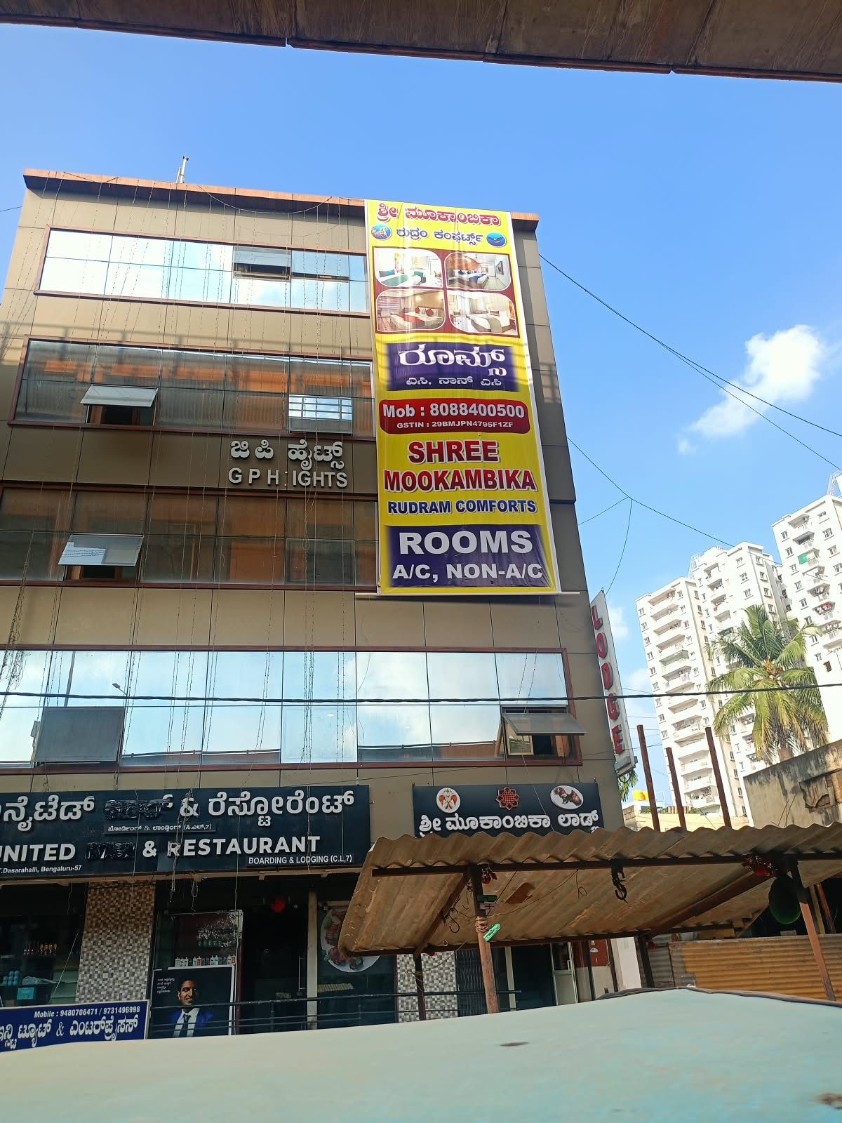 A multi-story building with commercial establishments on the ground floor, including a restaurant and a room booking service.