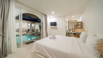 Habitación de hotel con cama, televisión, baño con espejo y zona de piscina.