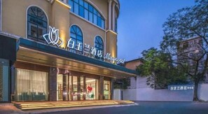 Un hôtel doté d’une entrée imposante, de grandes fenêtres et d’une enseigne avec des caractères chinois.