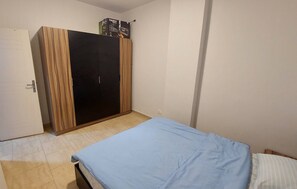 A bedroom with a bed, a wardrobe, and a door. - Luxurious Chalet in Red Sea Governorate with Stunning Sea Views (Red Sea Governorate)