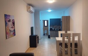 A narrow hallway leading to a kitchen with a microwave, cabinets, and a window. - Luxurious Chalet in Red Sea Governorate with Stunning Sea Views (Red Sea Governorate)