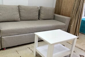 A grey sofa with a white table in front of it. - Chalet with side sea and pool view, Turtles Beach (Hurghada 2)