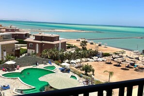 Resort com piscina, área de praia e vista para o oceano.