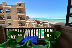 A balcony with a view of a beach and a pool. - Chalet with side sea and pool view, Turtles Beach (Hurghada 2)