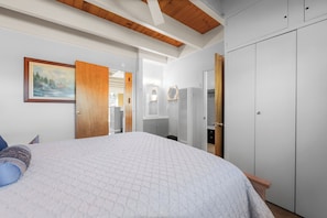 Ein Schlafzimmer mit einem großen Bett, einem Kleiderschrank und einem Bild an der Wand.