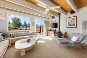 Ein modernes Wohnzimmer mit einer Couch, einem Couchtisch, einem Fernseher und einem Kamin.