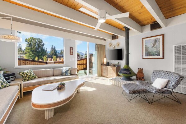 Una sala de estar moderna con un sofá, una mesa de centro, un televisor y una chimenea.