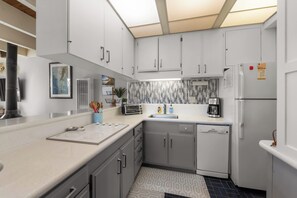 A modern kitchen with white cabinets, a built-in dishwasher, a coffee maker, and a toaster. - Keys Boating Escape - 1BR Home (South Lake Tahoe)