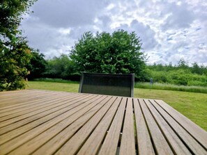 Ein Holztisch mit einem Metallstuhl in einem Garten.