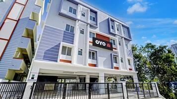 A multi-story hotel building with a modern architectural design, featuring a prominent sign for the hotel named 'OYO'.