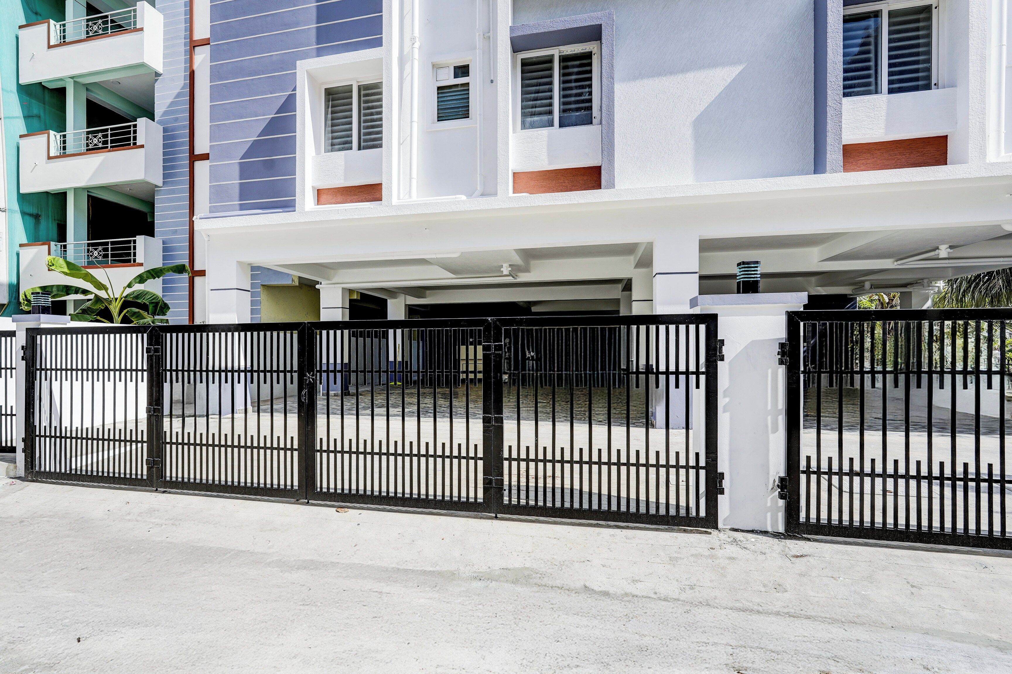 A multi-story residential building with a gated parking area.