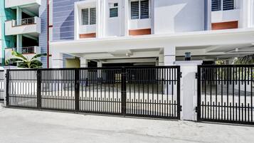 A multi-story residential building with a gated parking area.
