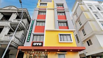 Un hotel de varios pisos con un cartel llamativo que dice 'HOTEL', un logotipo 'YOYO' y un cartel que dice 'HOTEL PLAZA'.