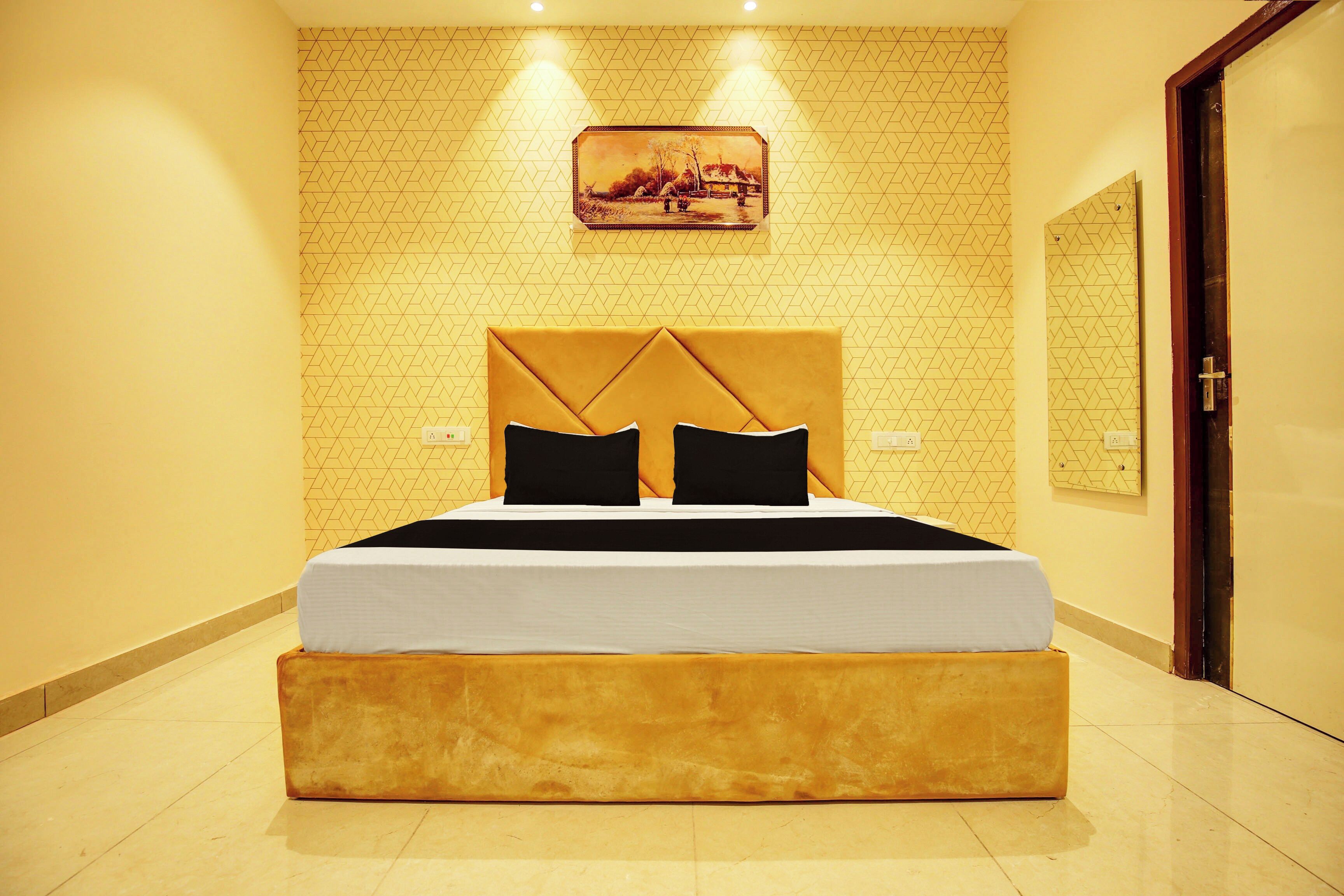 Une chambre d’hôtel avec un grand lit, une tête de lit et un tableau au mur.