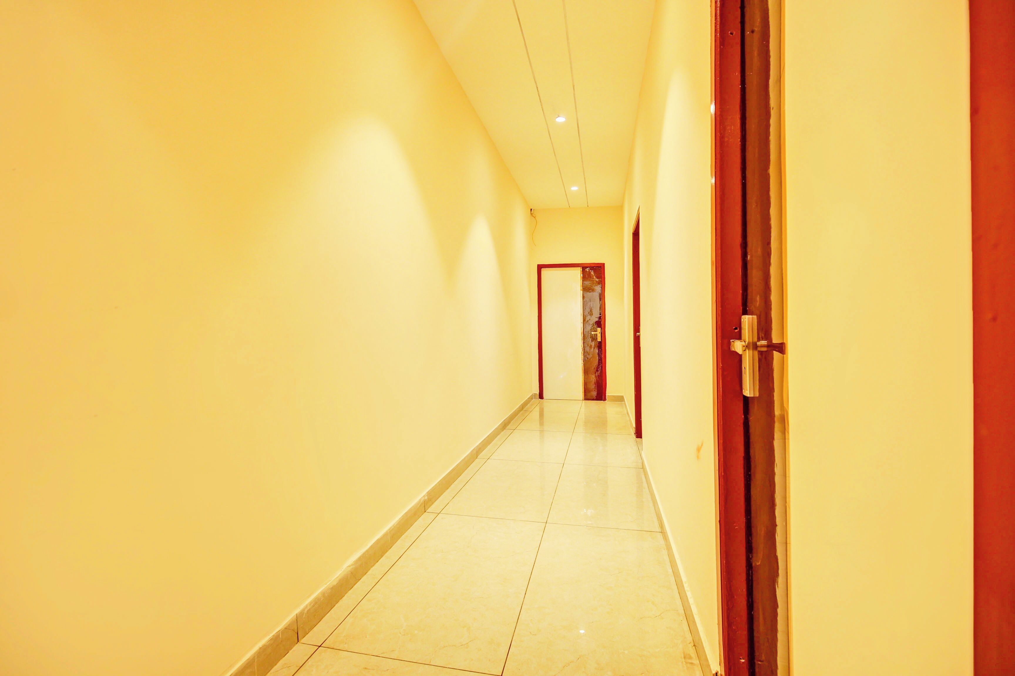 Un couloir avec un sol carrelé et une porte sur la droite.