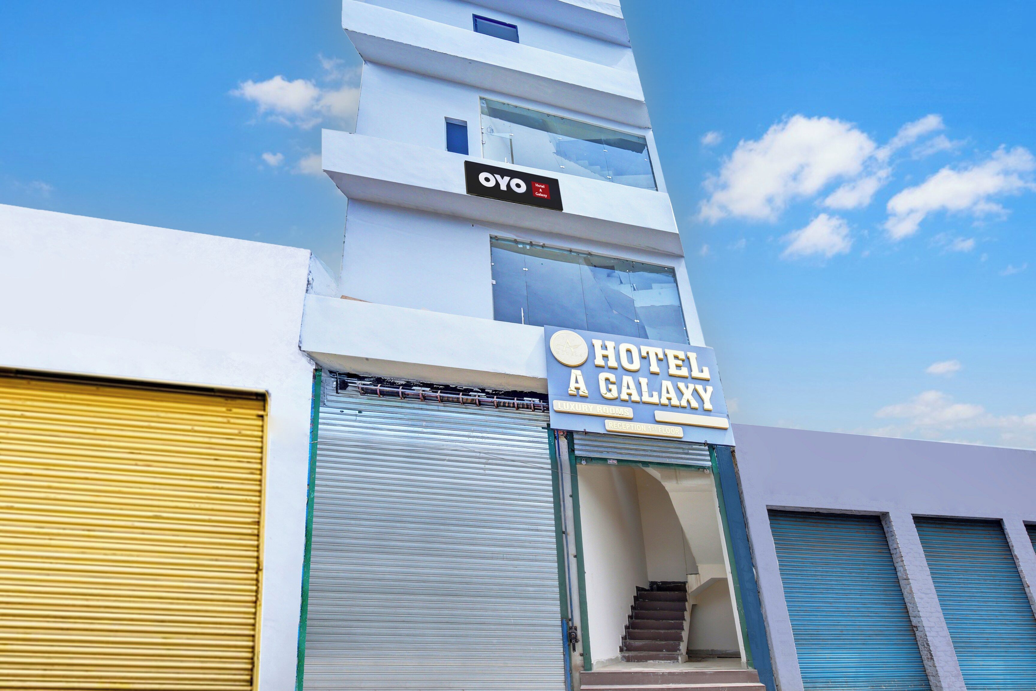 A hotel with a sign reading 'HOTEL A GALAXY' and a sign for 'OYO Hotel A Galaxy' above it.