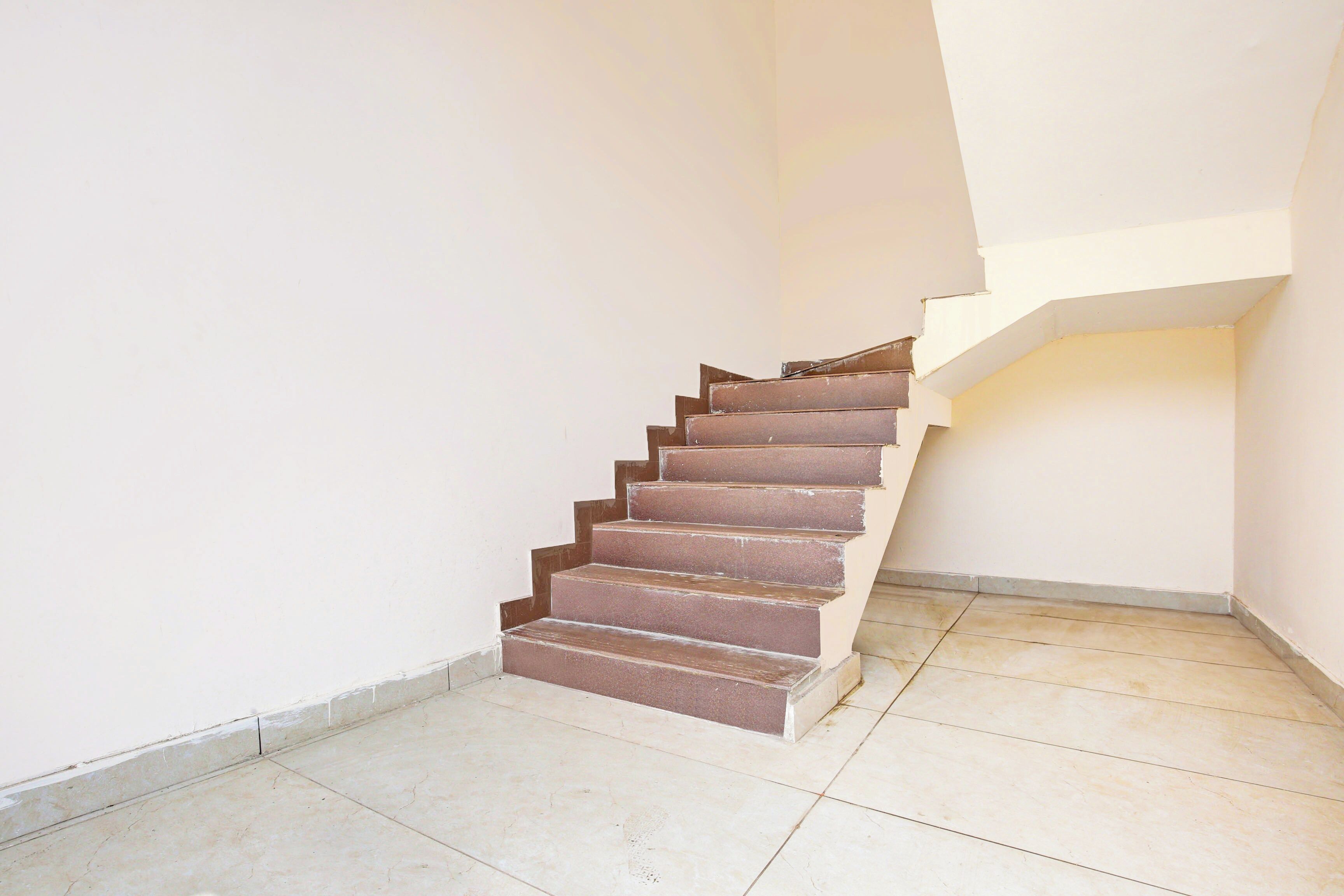 Un escalier avec une rampe, menant à un palier.