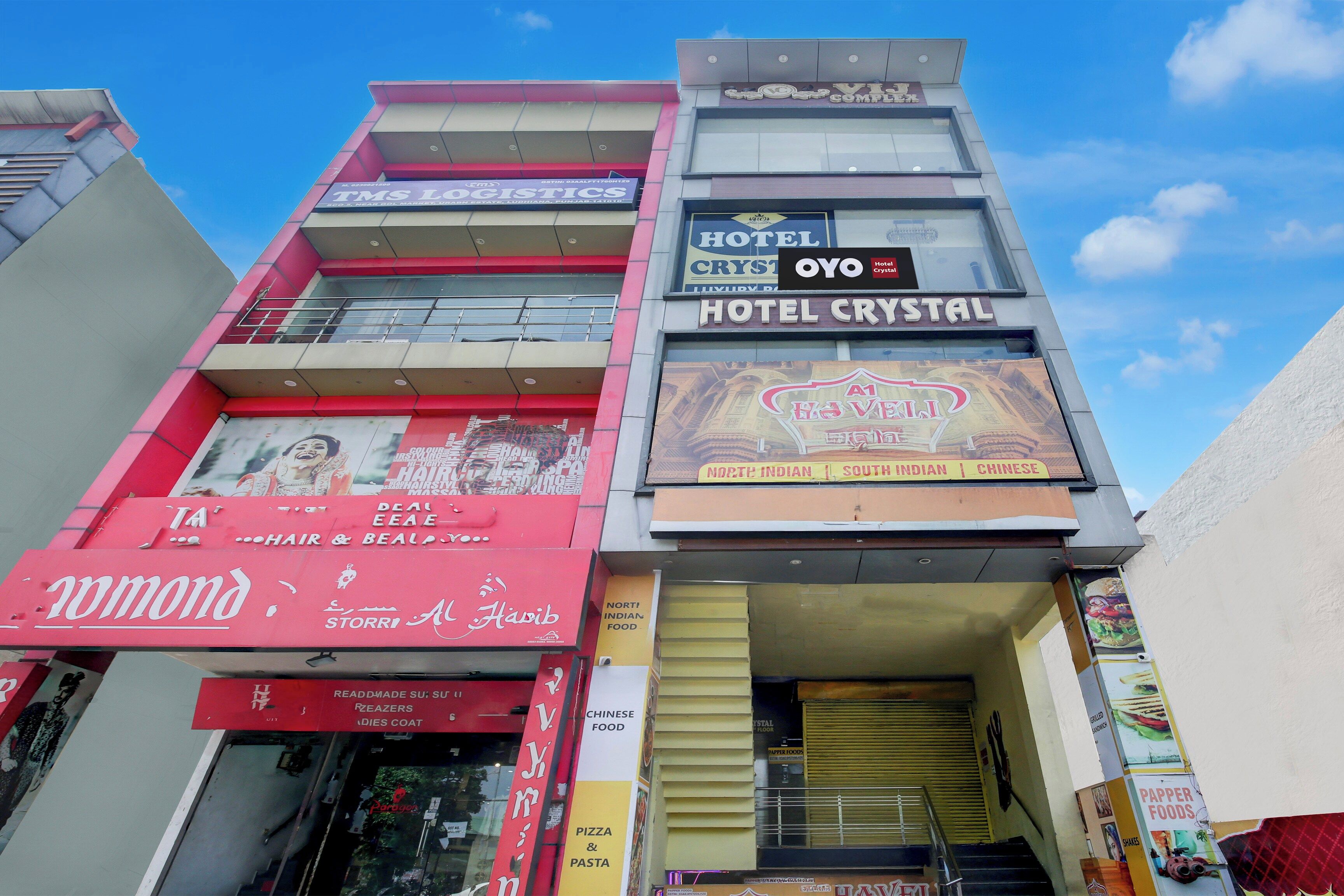 Un edificio de varios pisos con diversos establecimientos comerciales, incluyendo un hotel, un restaurante y una peluquería.