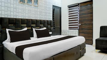 A modern bedroom with a large bed, a dark headboard, and a wooden door with blinds.
