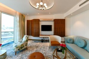 Una sala de estar moderna con un televisor de pantalla plana, un sofá, una silla y una alfombra estampada.