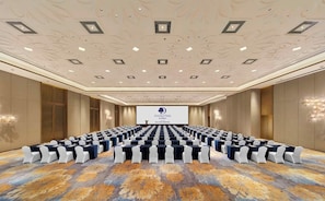 A conference room with rows of tables and chairs, a large screen at the front, and a patterned carpet. - Doubletree by Hilton Ya an (Ya'an)