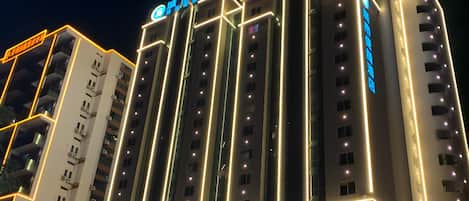 Un hotel de varios pisos con señalización iluminada y un diseño arquitectónico moderno.