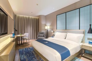 A hotel room with a bed, a desk, a chair, a lamp, and a large window. - Echarm Hotel Liuzhou Liudong Wuling Liuqi Branch (Liuzhou)