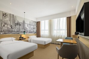 A hotel room with two beds, a desk, a chair, a TV, and a cityscape mural on the wall. - City Comfort Inn (Hechi)