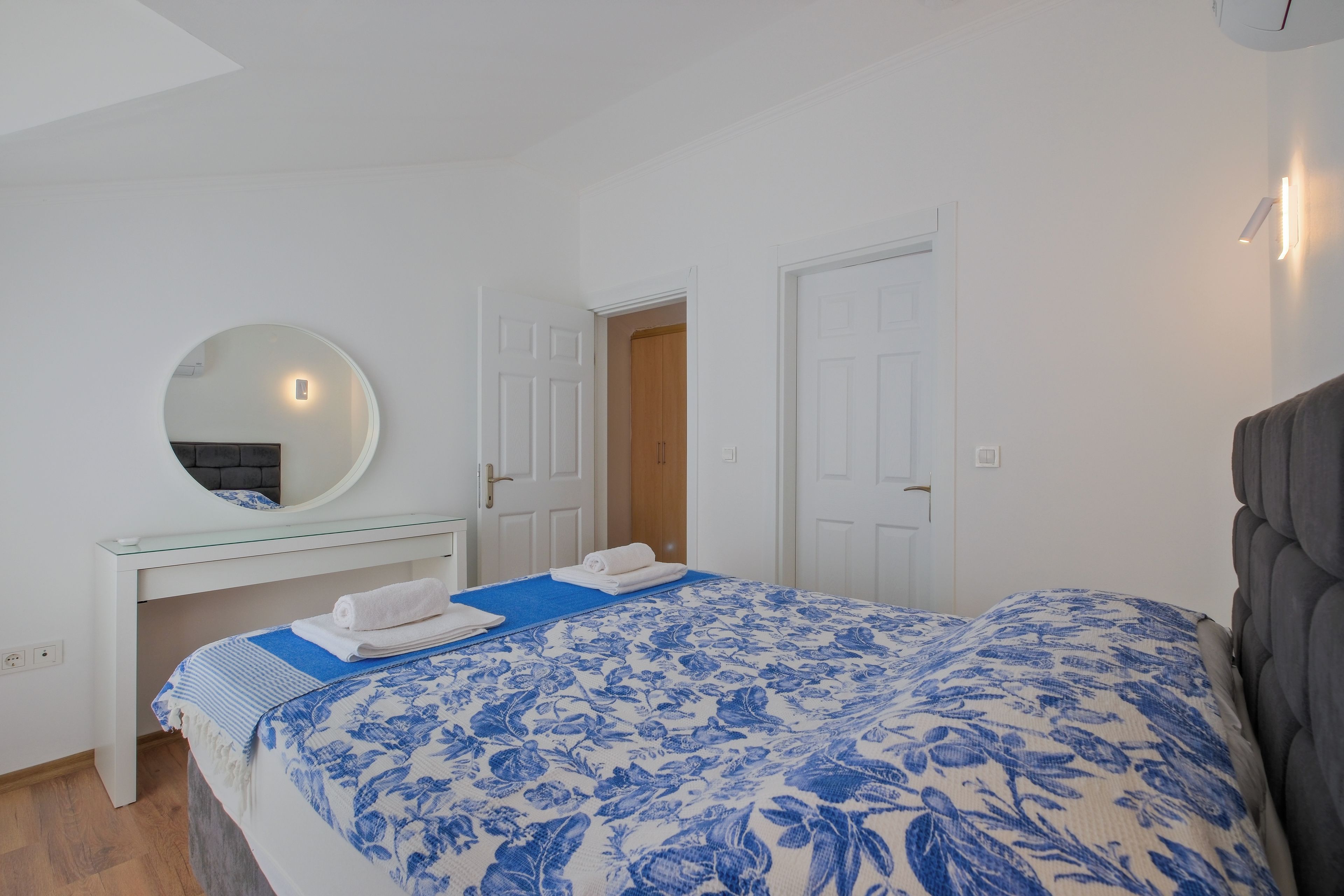 Una camera da letto con un letto, un comodino, uno specchio e un armadio.