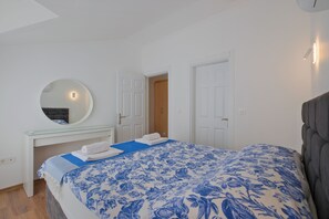 Une chambre à coucher avec un lit, une table de chevet, un miroir et une armoire.