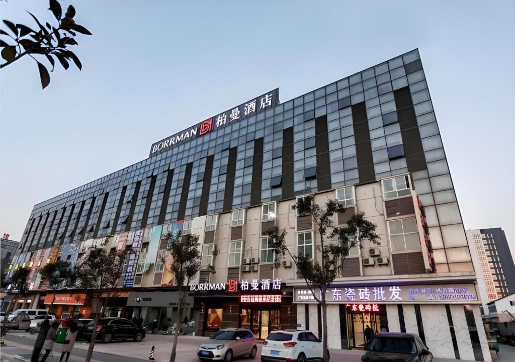 A modern hotel building with multiple floors, large windows, and a prominent sign for the Borrman hotel.