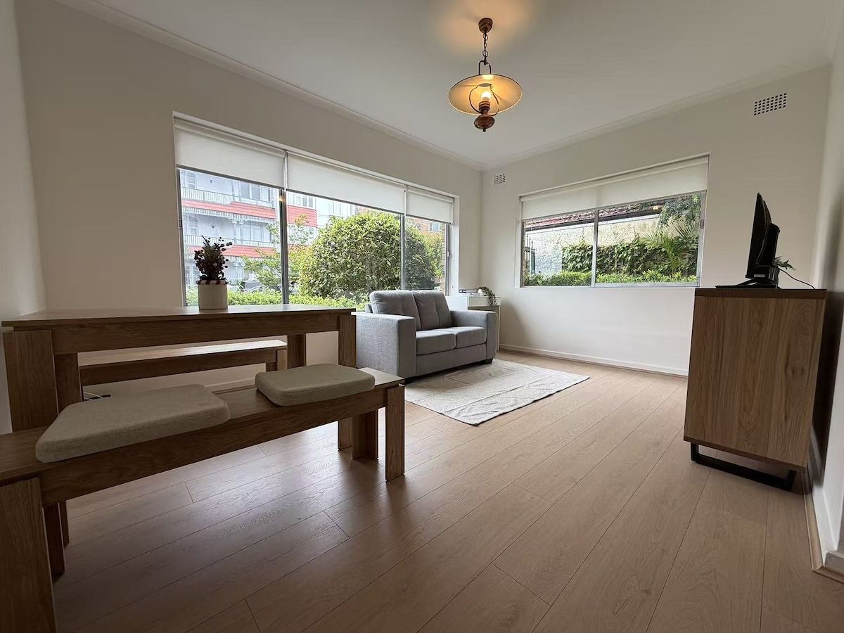 A spacious room with a wooden bench, a sofa, and a cabinet.
