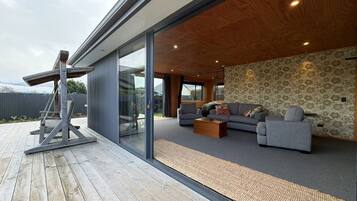 Un salon moderne avec un ensemble de canapés, une table basse et une terrasse en bois.