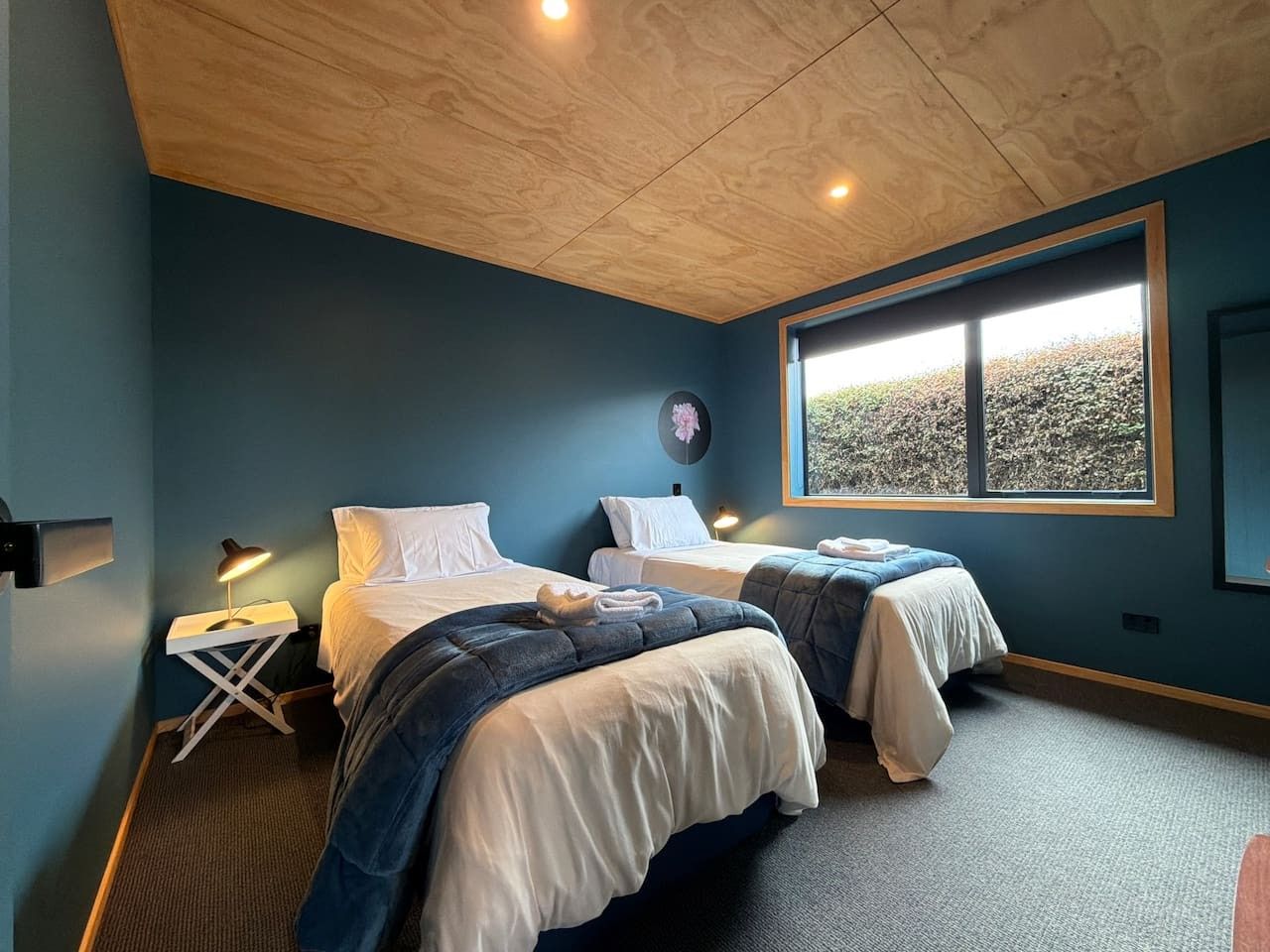 Une chambre avec deux lits, une fenêtre donnant sur un beau paysage et un plafond doté d’un éclairage encastré.