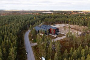 A large building surrounded by dense forest, with a road leading to it. - Levi North Apartment D11 by Aavalevi (Levi)