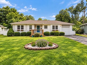 A single-story house with a front porch, a mailbox, and a well-maintained lawn. - Overland Park Retreat with Pool & Shuffleboard! (Overland Park)
