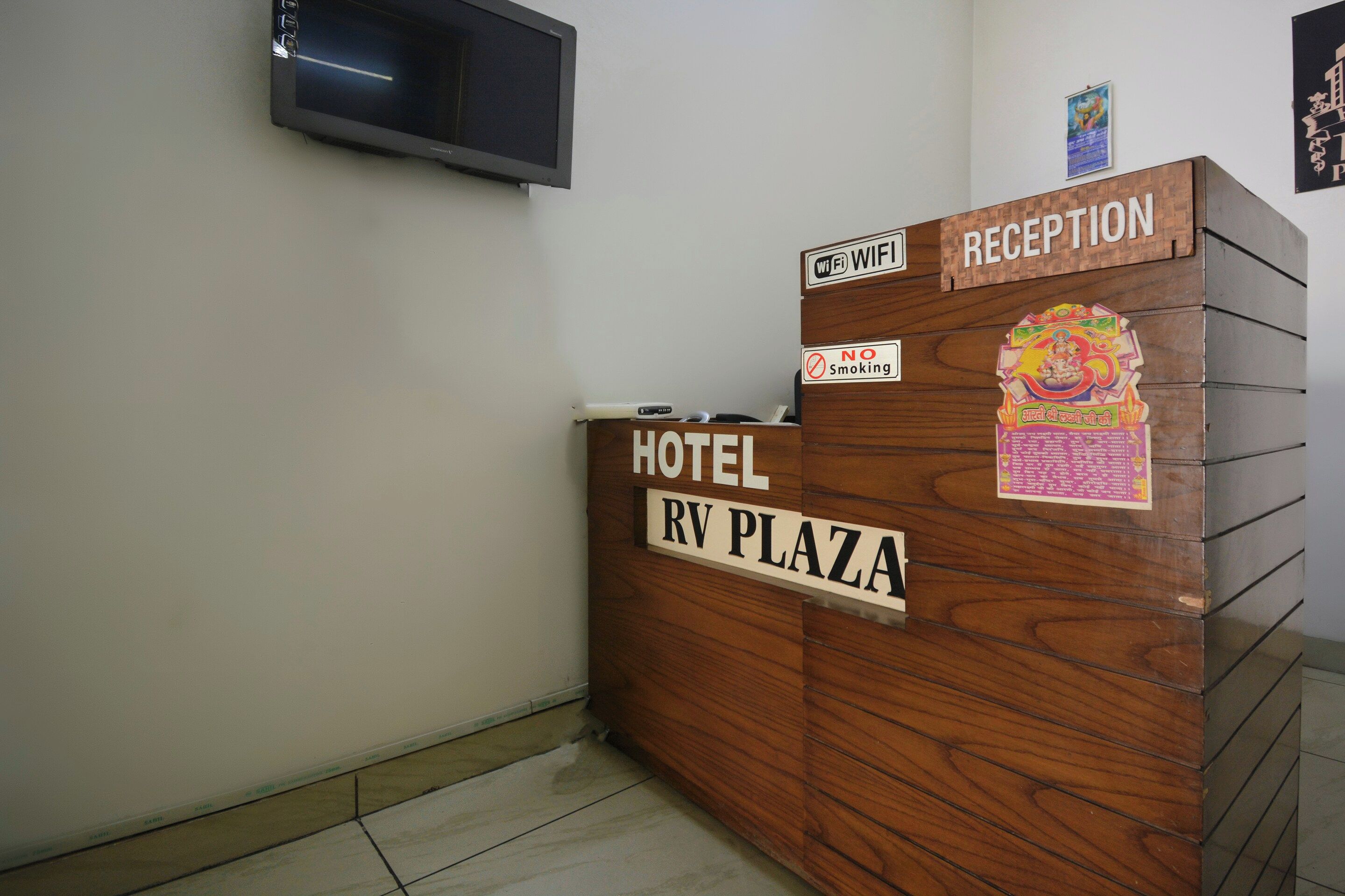 A hotel reception desk with a sign indicating 'Hotel RV Plaza' and 'Reception.'