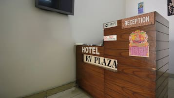 A hotel reception desk with a sign indicating 'Hotel RV Plaza' and 'Reception.'