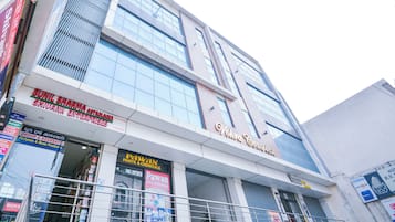 A multi-story commercial building with various storefronts, including a pharmacy, a paint store, and a hotel.