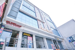 A multi-story commercial building with various storefronts, including a pharmacy, a paint store, and a hotel. - Hotel O Kings Inn (Ludhiana)