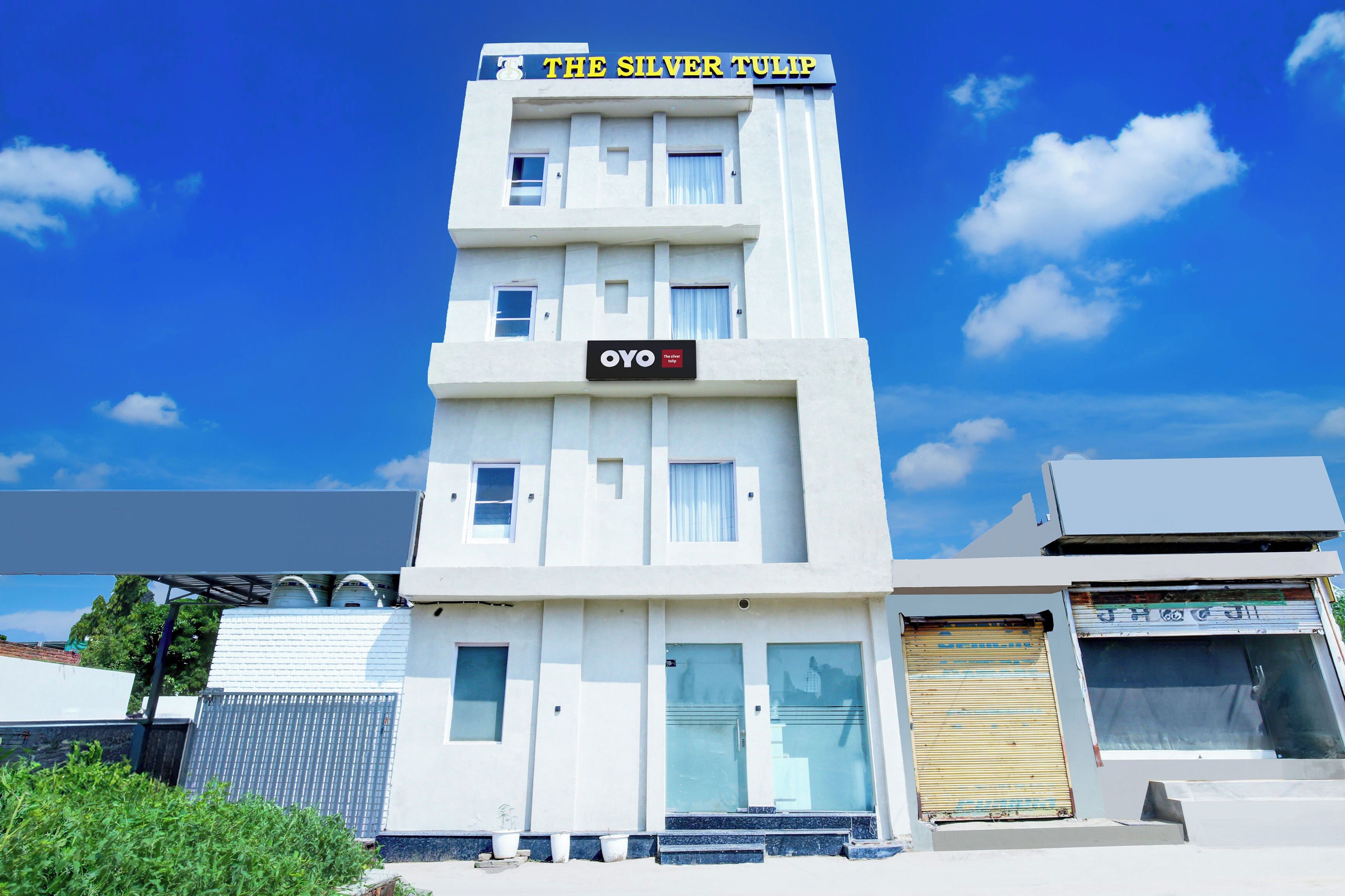 A building with a sign reading 'THE SILVER TULIP' and a smaller sign below it that says 'OYO The Better Tulip.'