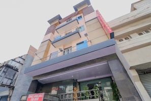 A multi-story building with balconies, a sign indicating space available for rent, and a storefront with glass doors. - Hotel O Shiv Pukhraj (Ludhiana)