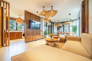 A modern living room with a sofa, coffee table, and TV. - Elegant 5BR Villa in Tropical Ubud with Pool+Patio (Gianyar Regency)