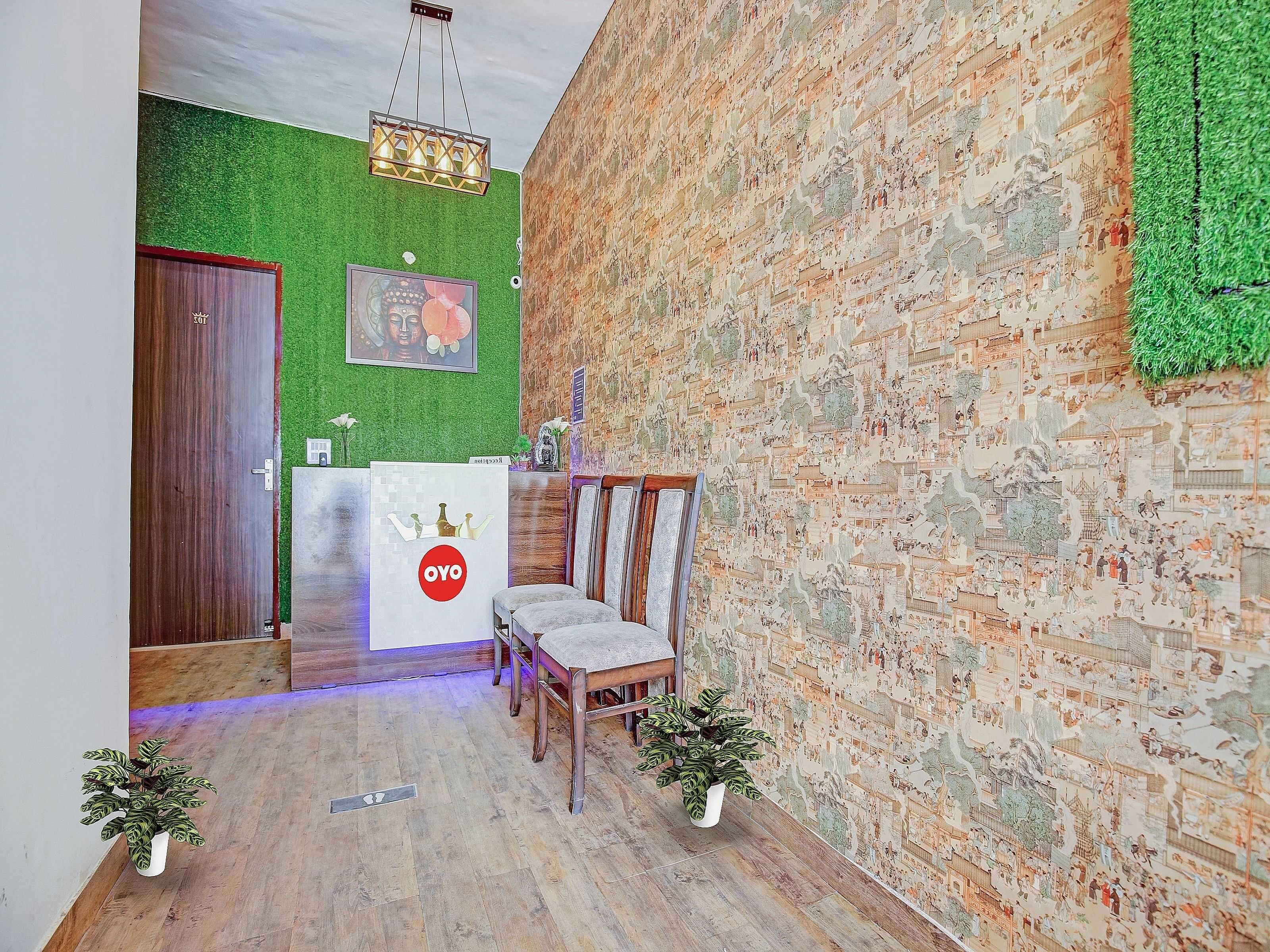 A reception area with a wooden reception desk, a green wall, and a brick wall.