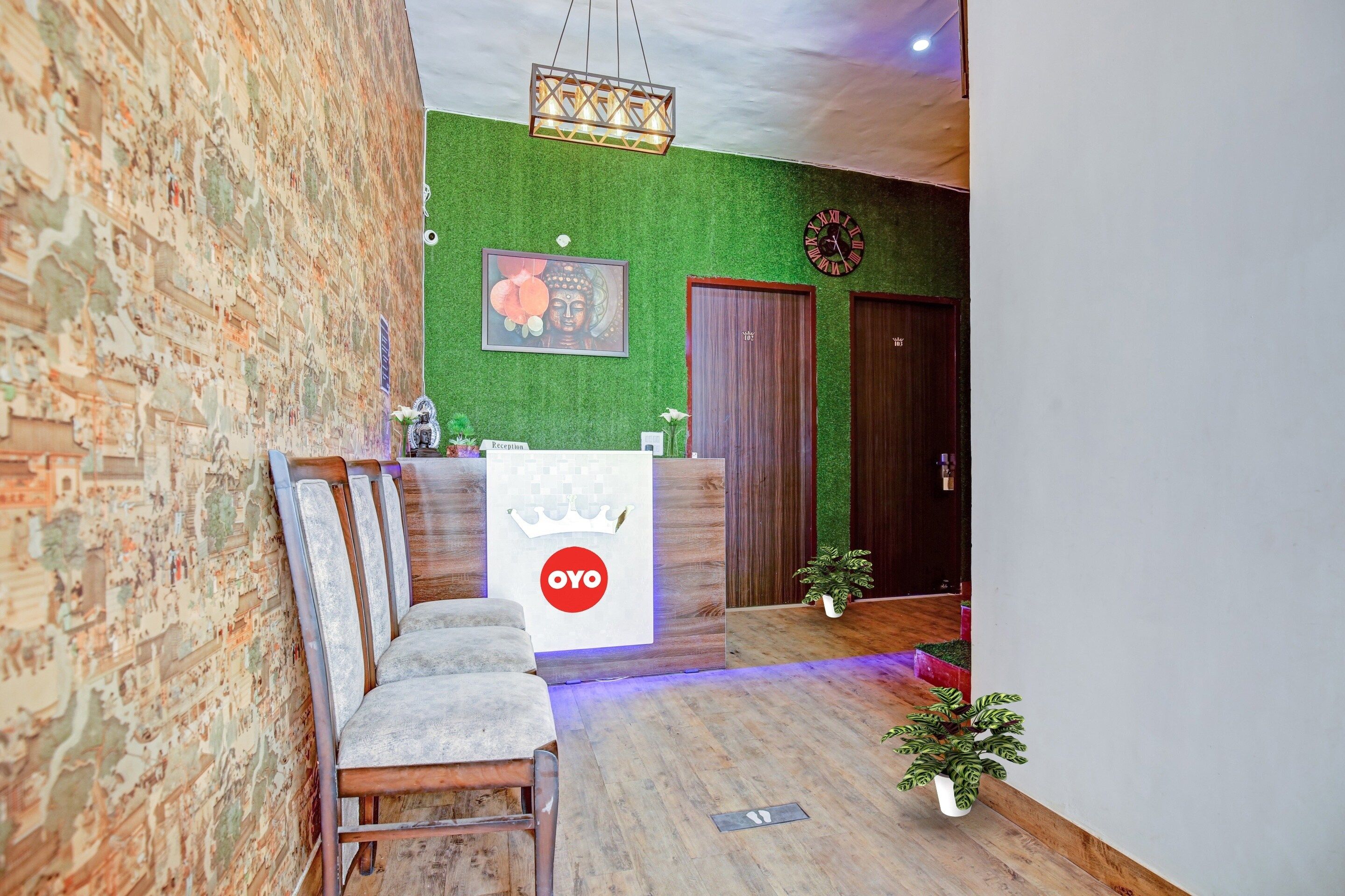 A reception area with a reception desk, a framed Buddha image, a clock, and a reception sign.