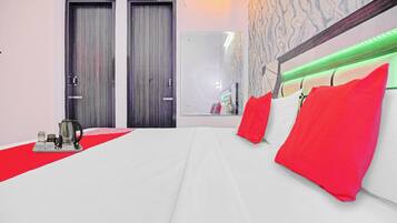 Una habitación de hotel con una cama, una bandeja con una tetera y dos puertas.