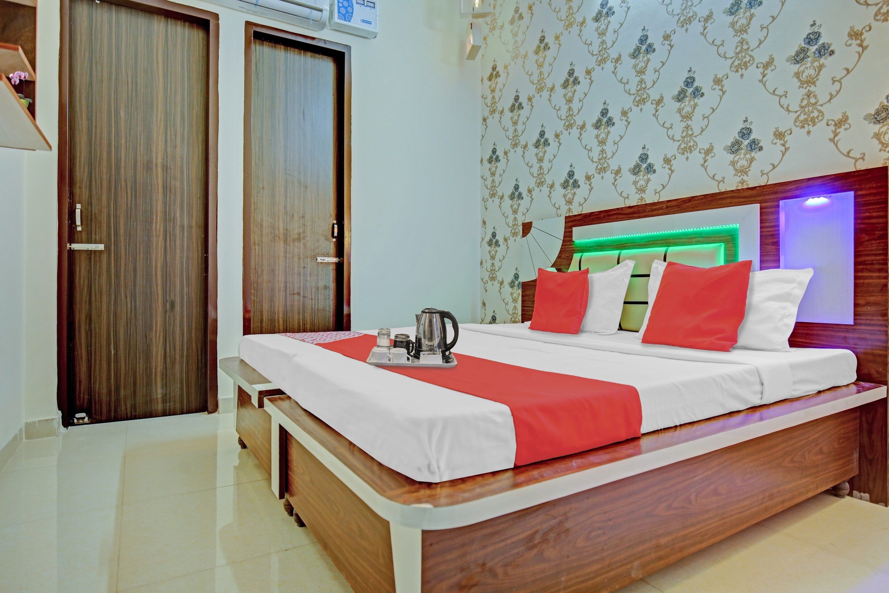 A hotel room with a bed, bedside table, and a wardrobe.