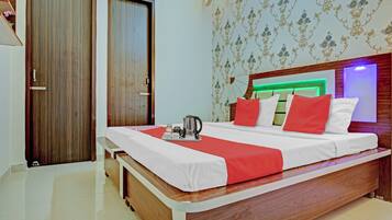 A hotel room with a bed, bedside table, and a wardrobe.