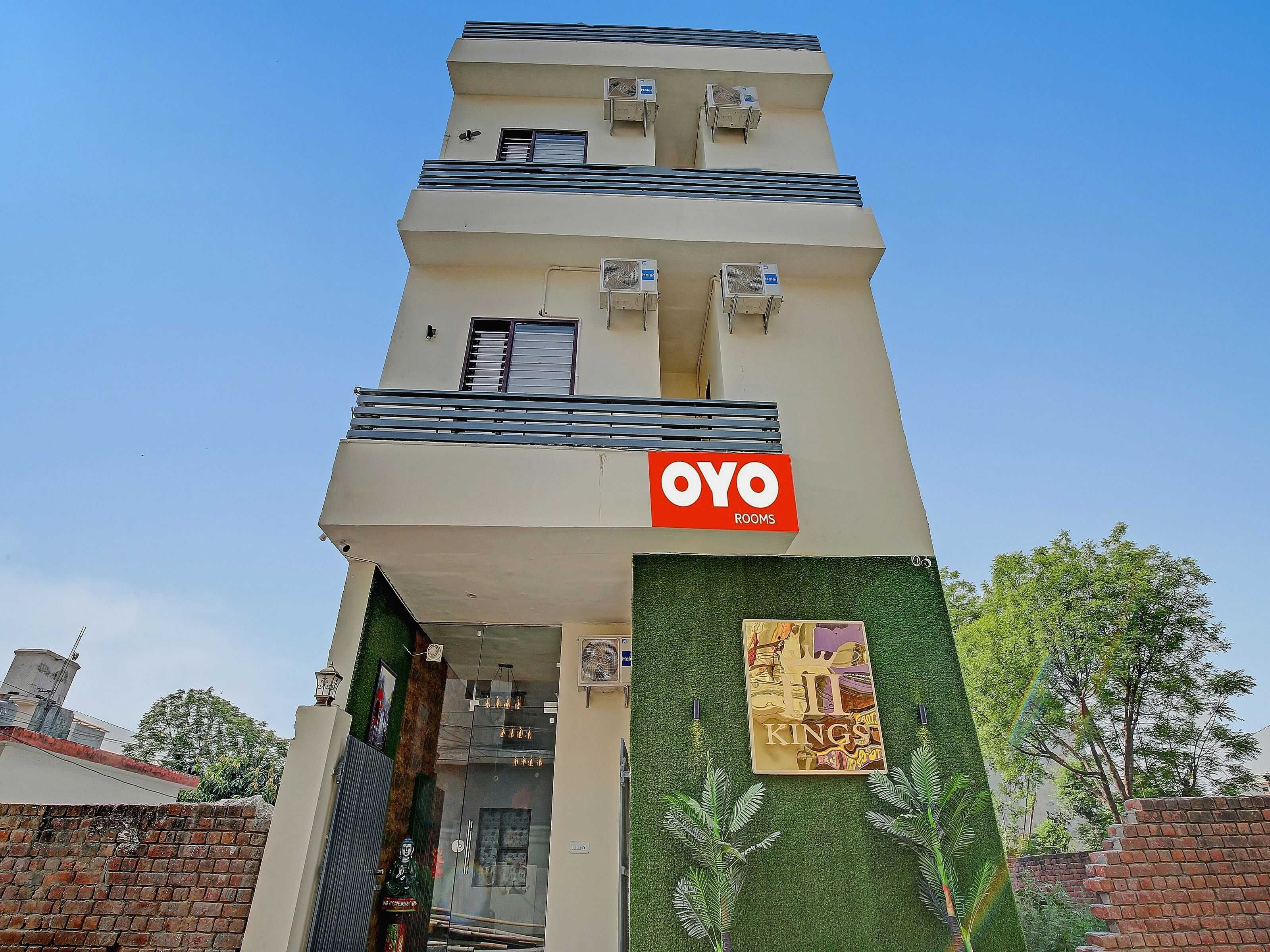 Un edificio con un letrero que dice 'OYO Rooms' y un letrero que dice 'Kings' en la entrada.